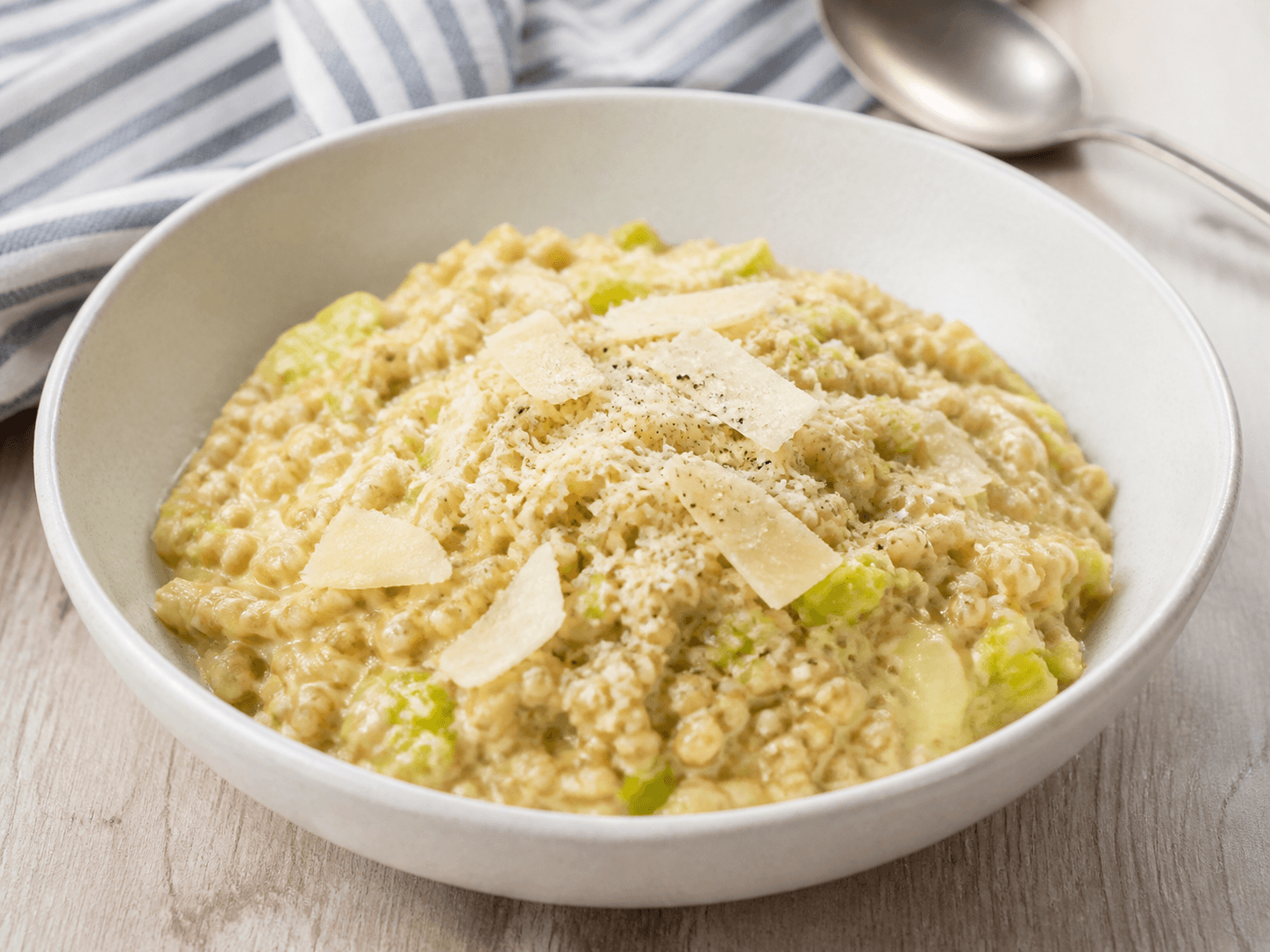 Bol de blé crémeux façon risotto avec poireaux fondants et copeaux de parmesan.