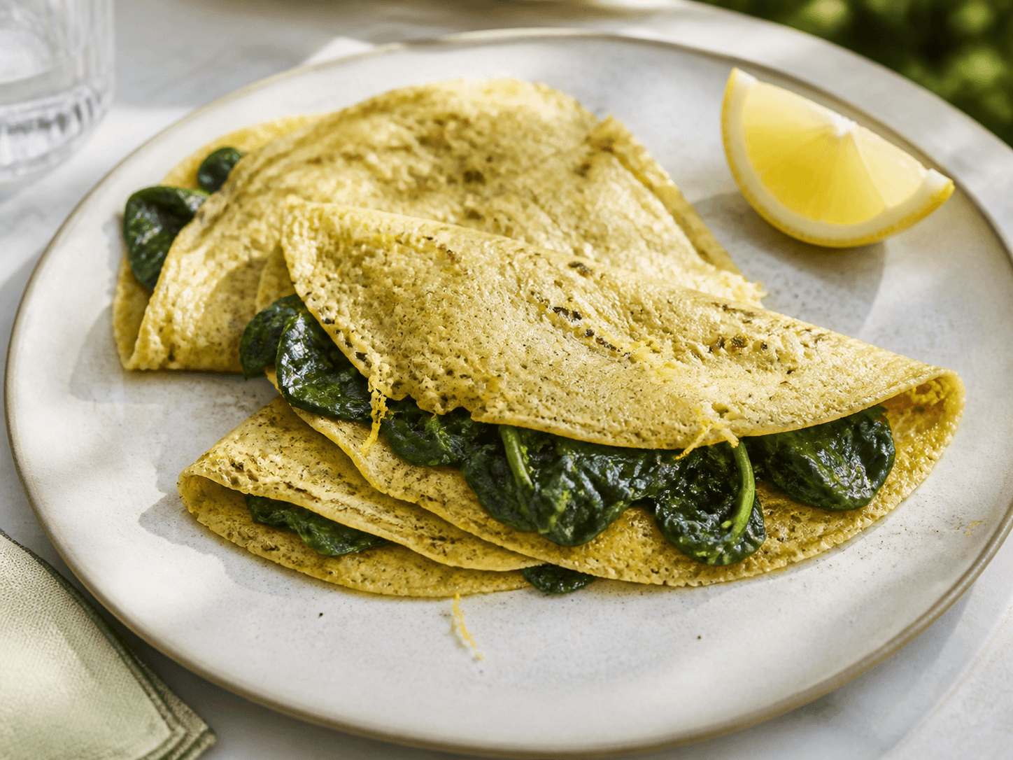 Crêpes de pois chiches aux épinards et citron, plat terminé présenté naturellement
