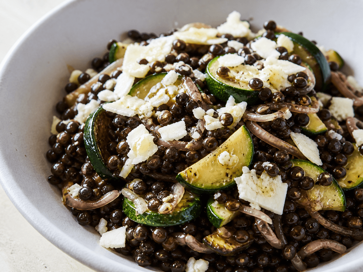Poêlée de lentille noire, courgette trompette et chèvre sec, plat terminé présenté naturellement