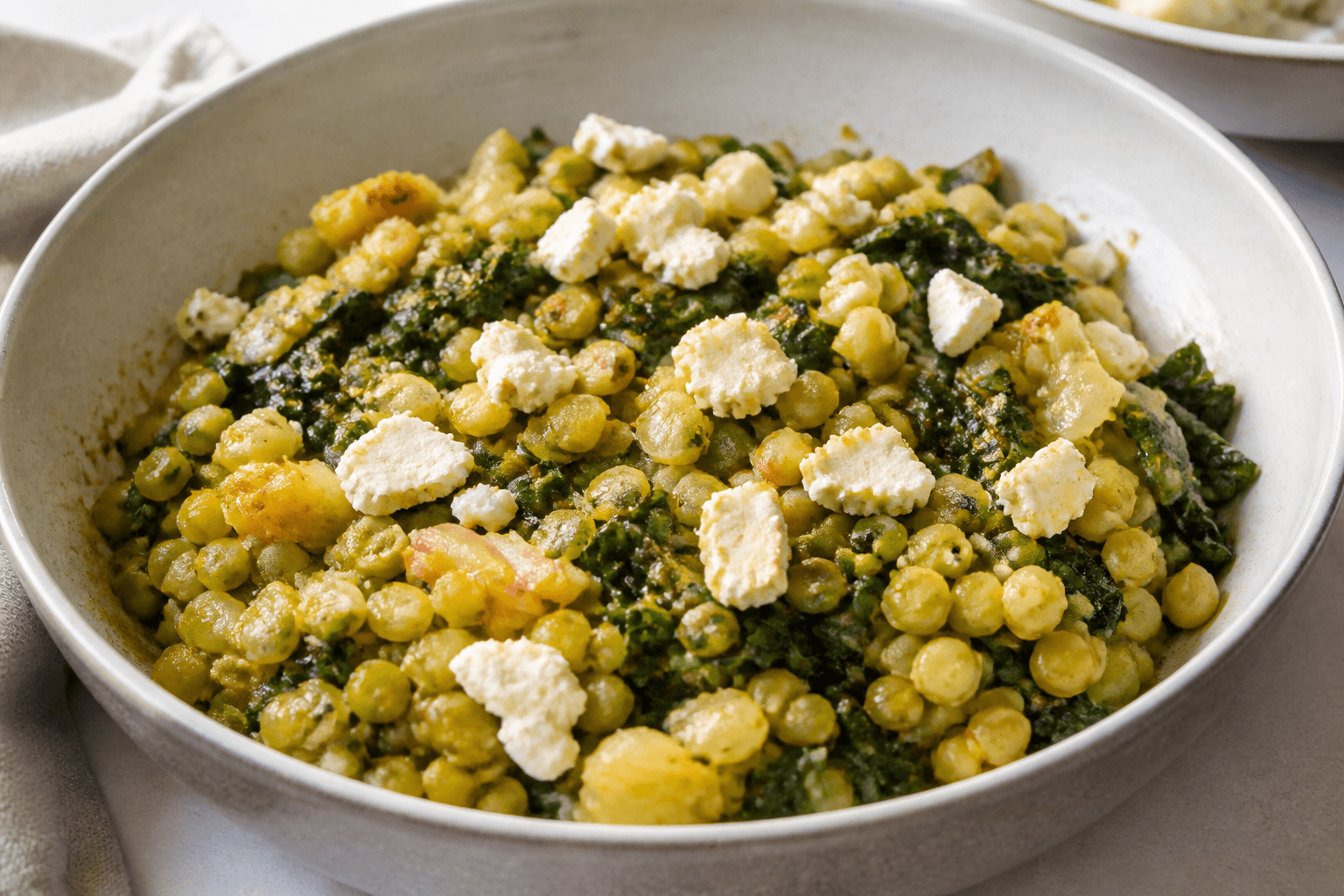 Poêlée de pois cassés verts, bettes et chèvre affiné, plat terminé présenté naturellement