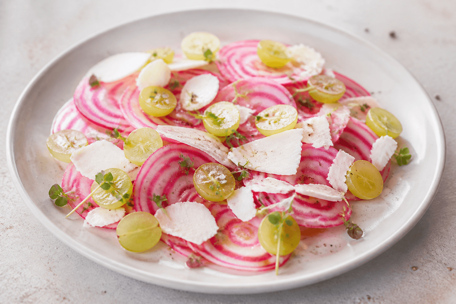 Salade de betterave chioggia, raisin blanc et chèvre sec, plat terminé présenté naturellement