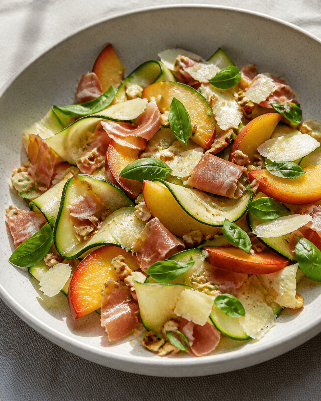 Salade de courgettes crues, nectarines et jambon sec, plat terminé présenté naturellement
