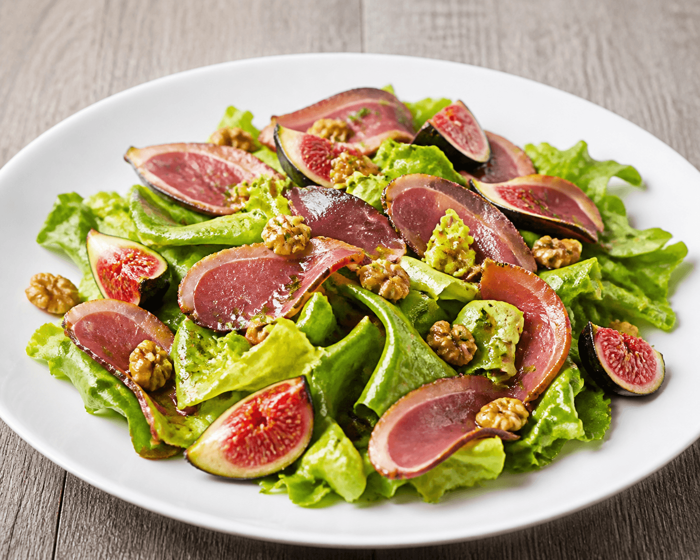 Salade de laitue batavia, figue et magret fumé, plat terminé présenté naturellement
