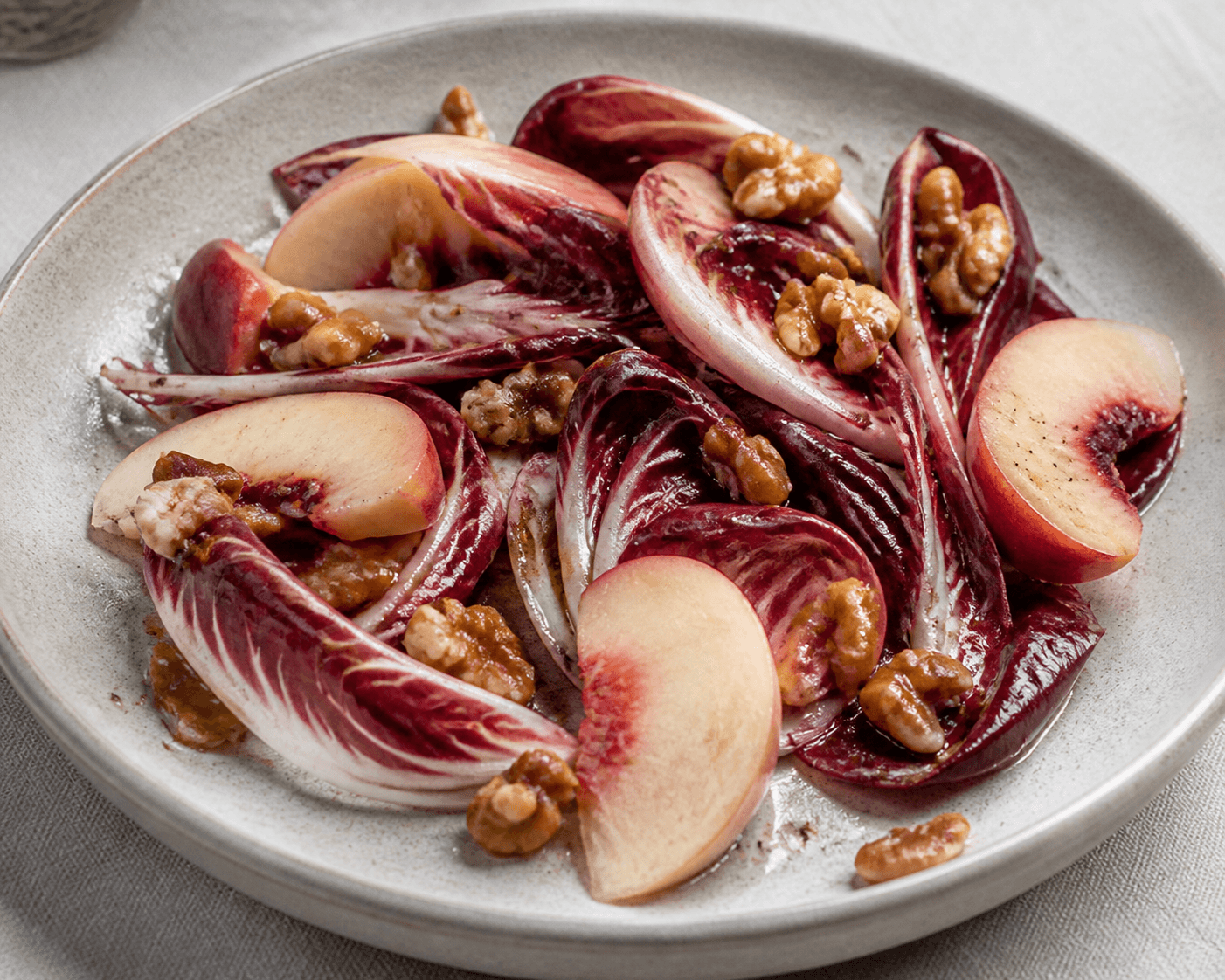 Salade de trévise, pêche blanche et noix fraîches, plat terminé présenté naturellement